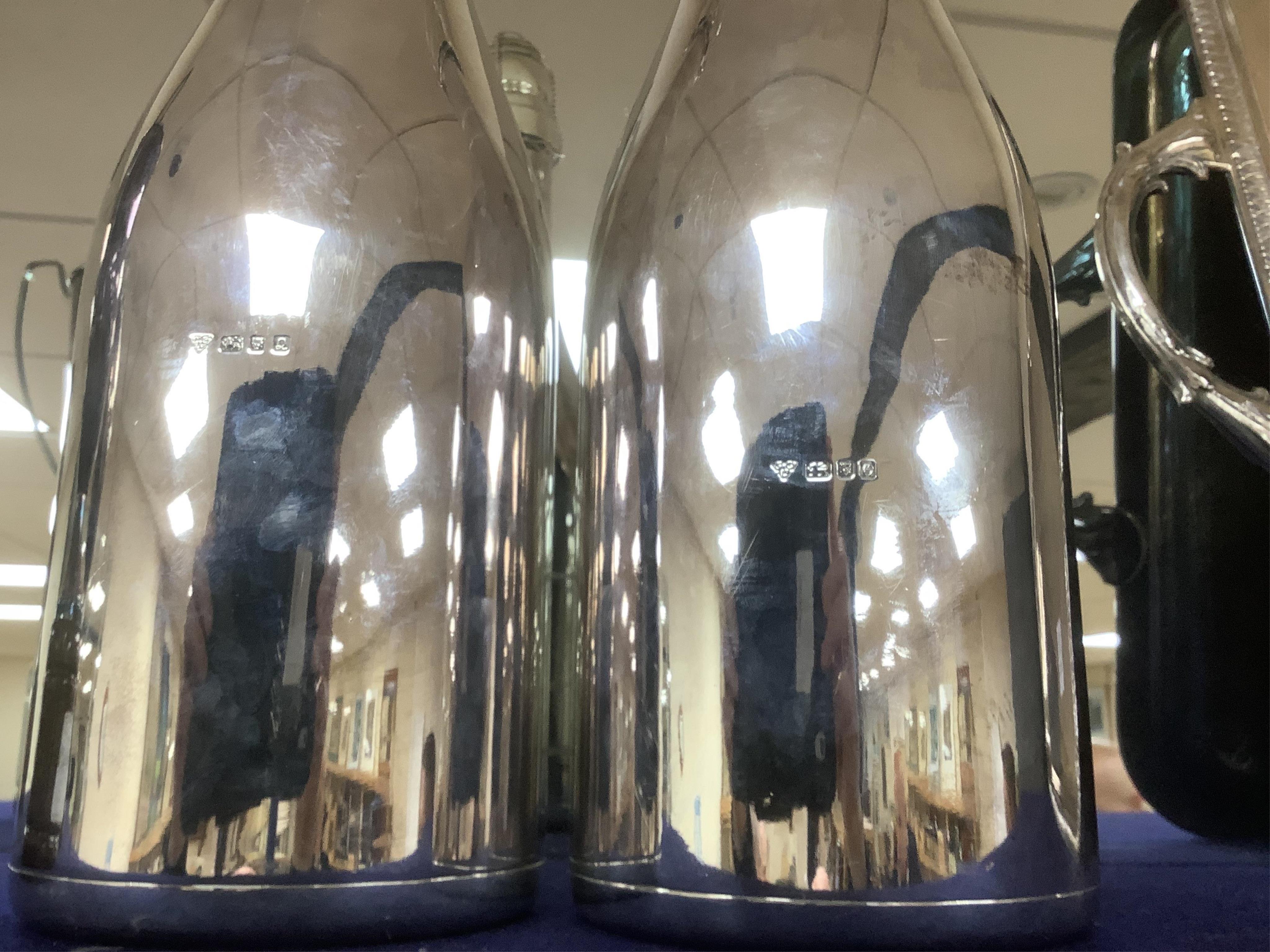 A near pair of Elizabeth II silver presentation magnum bottles by Garrard & Co inscribed 'Moet & Chandon Silver Magnums, Epsom 28th August 1989' and 'Sandown Park, 27th August, 1990', both won by 